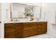 Modern bathroom with double sinks, wood cabinets, a marble countertop, and a large mirror at 484 87Th Avenue North, St Petersburg, FL 33702