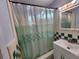 Bathroom featuring a shower-tub combo with white and green tiling at 5209 10Th S Ave, Gulfport, FL 33707