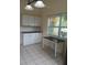 Corner kitchen with a window providing lots of sunlight and white cabinets with black countertops at 5209 10Th S Ave, Gulfport, FL 33707