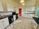 Functional kitchen featuring white cabinets, black appliances, and tile flooring at 5209 10Th S Ave, Gulfport, FL 33707