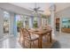 Bright dining room featuring a wood table set and large windows with backyard view and light blue curtains at 5366 Hader Rd, North Port, FL 34288