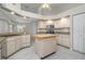 Well-lit kitchen featuring a center island with butcher block countertop, stainless steel appliances, and white cabinetry at 5366 Hader Rd, North Port, FL 34288