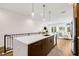 Open kitchen features wood cabinets, stainless appliances, and a large island with white countertop and railing at 8631 5Th Street North, St Petersburg, FL 33702