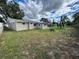 Wide view of the backyard featuring a spacious lawn and access to a screened porch at 3341 Wiltshire Dr, Holiday, FL 34691