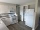 Kitchen featuring stainless steel appliances, white cabinets, and wood-look floors at 3341 Wiltshire Dr, Holiday, FL 34691