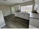 Bright kitchen features stainless steel appliances, white cabinets, and wood-look floors at 3341 Wiltshire Dr, Holiday, FL 34691