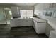 Bright kitchen features stainless steel sink, white cabinetry with gray counter tops, and plank flooring at 3341 Wiltshire Dr, Holiday, FL 34691