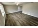 Spacious living room with modern floors, a ceiling fan, and natural light from the large window at 3341 Wiltshire Dr, Holiday, FL 34691