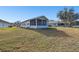 Backyard view of the screened porch and well-maintained lawn at 37401 Wedgewood Dr, Zephyrhills, FL 33542