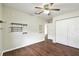 Bedroom with wood floors, a ceiling fan, and built in shelving at 37401 Wedgewood Dr, Zephyrhills, FL 33542