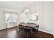 Dining area featuring hardwood floors, decorative chandelier, and pass-through to the kitchen at 37401 Wedgewood Dr, Zephyrhills, FL 33542