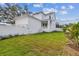 View of the back of the home featuring a well-kept lawn, landscaping, and a white privacy fence at 441 42Nd Ne Ave, St Petersburg, FL 33703