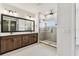 Modern bathroom featuring double sinks, granite countertops, dark wood cabinets, and a glass shower at 441 42Nd Ne Ave, St Petersburg, FL 33703