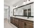 Bathroom featuring a large framed mirror, double vanity with a marble countertop, and wood cabinets at 441 42Nd Ne Ave, St Petersburg, FL 33703