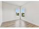 Bright bedroom with wood-look laminate flooring and two windows offering neighborhood views at 441 42Nd Ne Ave, St Petersburg, FL 33703