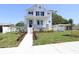Charming two-story home with landscaped front yard and elegant entryway with a stairway up to the front door at 441 42Nd Ne Ave, St Petersburg, FL 33703