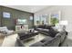 Open-concept living room with large windows, gray sofa, and modern furnishings at 441 42Nd Ne Ave, St Petersburg, FL 33703