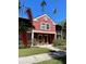 Charming two-story condo with a red stucco exterior, complemented by green landscaping and a clear blue sky at 5557 Baywater Dr, Tampa, FL 33615