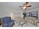 Bright living room with tile floors, floral print sofas, ceiling fan and large windows offering natural light at 5557 Baywater Dr, Tampa, FL 33615