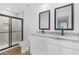 Modern bathroom with double sink vanity, granite counters, sleek fixtures, and glass-enclosed shower at 5710 Humkey St, North Port, FL 34291