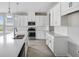 Bright kitchen with stainless appliances, white cabinetry, an island sink, and tiled backsplash and floors at 2061 Longliner Loop, Wesley Chapel, FL 33543