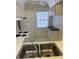 Bright kitchen featuring white appliances, double stainless steel sink, and white cabinets at 3115 Mission Grove Dr, Palm Harbor, FL 34684