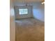Bright and airy living room with large windows and neutral colored carpet at 3115 Mission Grove Dr, Palm Harbor, FL 34684