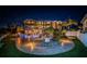 Magnificent waterfront estate featuring a luxurious pool area, lush landscape, and exterior lighting at 335 Bath Club S Blvd, North Redington Beach, FL 33708