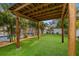 Inviting backyard patio area with a wooden pergola, lush green turf, and tropical landscaping for relaxing and entertaining at 4210 Harrisburg Ne St, St Petersburg, FL 33703