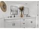 Bright bathroom boasts dual sinks, modern black hardware, white cabinetry and quartz countertop at 4210 Harrisburg Ne St, St Petersburg, FL 33703