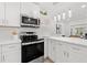 Bright kitchen features stainless steel appliances, white cabinets, and a large countertop at 4210 Harrisburg Ne St, St Petersburg, FL 33703