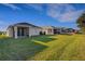 View of a spacious backyard showcasing lush grass and a covered patio at 5811 Arbor Wood Ct, Bradenton, FL 34203