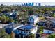 An aerial view of houses with solar panels, mature trees and a city skyline in the background at 818 W Adalee St, Tampa, FL 33603