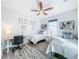 Bright bedroom with hardwood floors, two beds, a ceiling fan, and a study area, ideal for a growing Gathering at 818 W Adalee St, Tampa, FL 33603