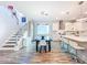 Open-concept dining area with modern lighting, a staircase, and a view of the kitchen with white cabinetry at 818 W Adalee St, Tampa, FL 33603