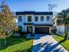 Striking two-story home with a paved driveway, manicured lawn, and contemporary architectural design at 818 W Adalee St, Tampa, FL 33603