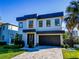 Modern home with a two-car garage, well-manicured landscaping, and a paver driveway at 818 W Adalee St, Tampa, FL 33603