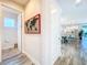 Hallway view leading to a modern kitchen and dining area, featuring sleek tile flooring and neutral decor at 818 W Adalee St, Tampa, FL 33603