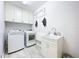 Clean and functional laundry room with washer, dryer, sink, and storage cabinets at 818 W Adalee St, Tampa, FL 33603