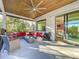 Covered patio with comfortable seating, ceiling fan, and view of the lush backyard through sliding glass doors at 818 W Adalee St, Tampa, FL 33603