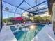 Screened-in pool with lounge chairs, a red umbrella, and view of the backyard at 818 W Adalee St, Tampa, FL 33603