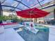 Enclosed pool with lounge chairs, umbrella, and a view of the backyard landscaping at 818 W Adalee St, Tampa, FL 33603