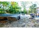 Backyard featuring a trampoline, palm trees, and Adirondack chairs around a fire pit, perfect for outdoor activities at 895 64Th S Ave, St Petersburg, FL 33705