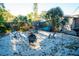 Tranquil backyard featuring an outdoor gathering space with palm trees and Adirondack seating around a fire pit at 895 64Th S Ave, St Petersburg, FL 33705