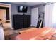 This cozy bedroom has wood floors, a TV, two dressers, a mirror, and an access door to another room at 895 64Th S Ave, St Petersburg, FL 33705