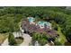 Stunning aerial view of the community clubhouse and pool surrounded by lush trees at 19724 Post Island Loop, Land O Lakes, FL 34638