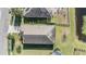 Aerial view of a single-Gathering home with a dark roof, green lawn, and a nearby pond at 19724 Post Island Loop, Land O Lakes, FL 34638