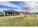 A large backyard with green grass and a white picket fence surrounds a young shade tree at 19724 Post Island Loop, Land O Lakes, FL 34638