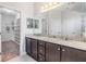 Bright bathroom features a double vanity with granite countertops and leads to a spacious walk-in closet at 19724 Post Island Loop, Land O Lakes, FL 34638