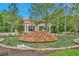 Elegant community entrance with a stone fountain, lush landscaping, and a gatehouse at 19724 Post Island Loop, Land O Lakes, FL 34638
